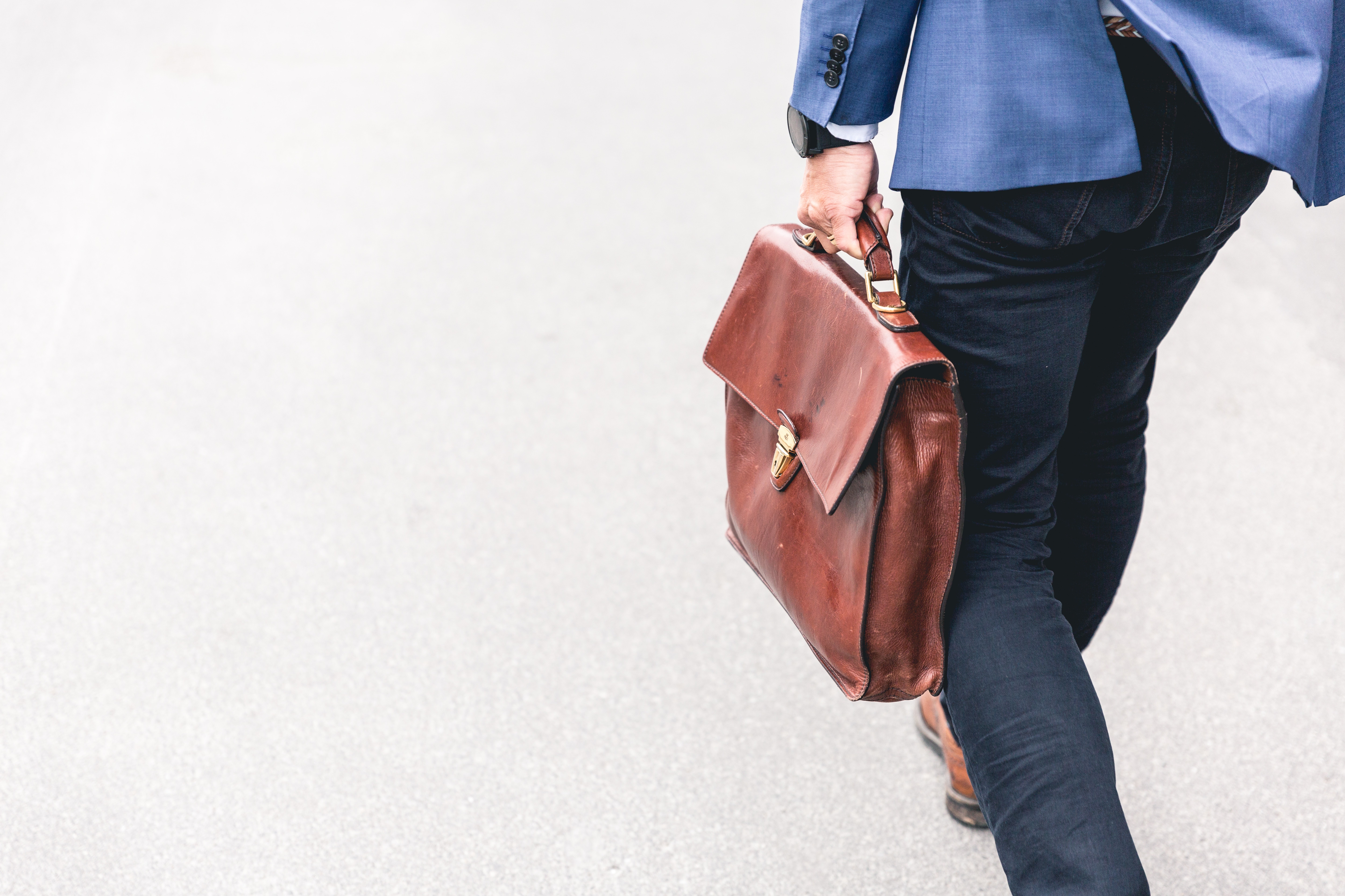 man carrying briefcase photo by marten bjork