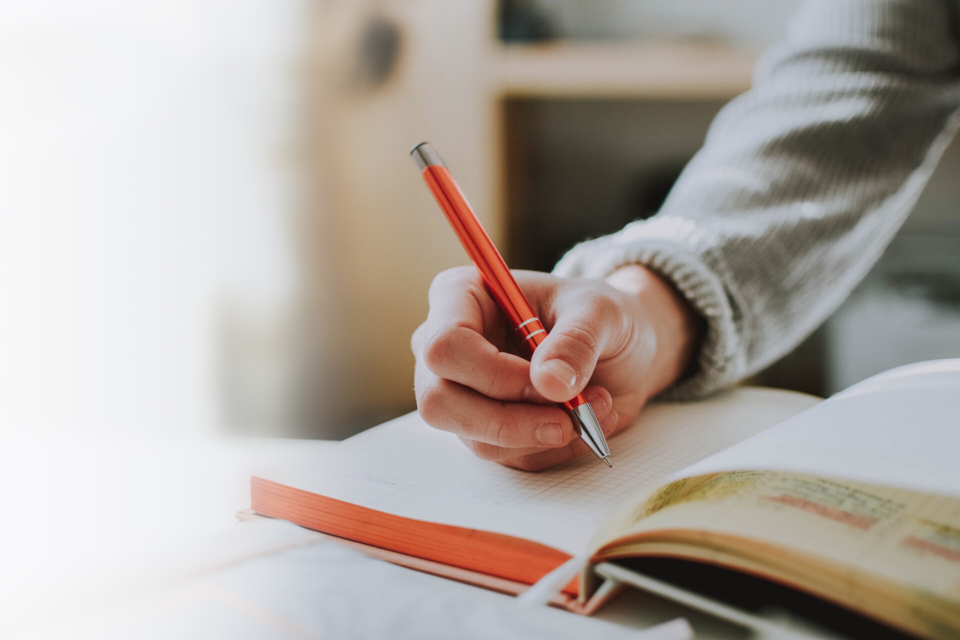 person-holding-orange-pen-photo-via-unsplash